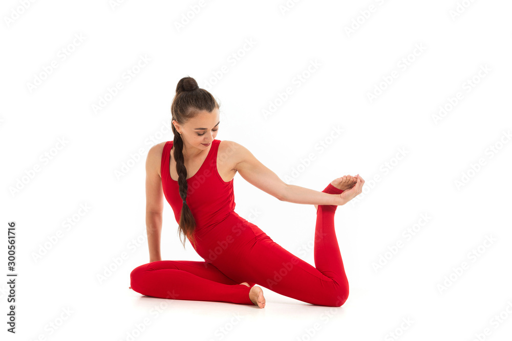 A beautiful young female gymnast sits on a floor and does warm-up and stretch muscles A beautiful young female gymnast sits on a floor and does warm-up and stretch muscles