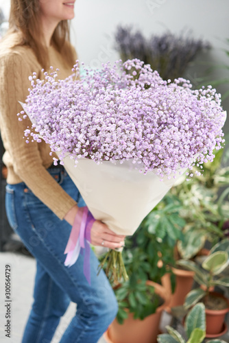 Lilac gypsophila. Beautiful bouquet of mixed flowers in womans hands. the work of the florist at a flower shop. Fresh cut flower.
