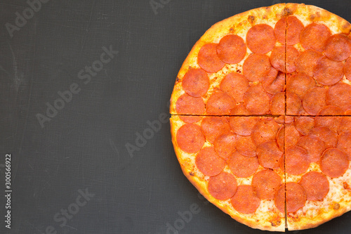 Tasty Pepperoni pizza over black background, top view. Overhead, from above, flat lay. Copy space.