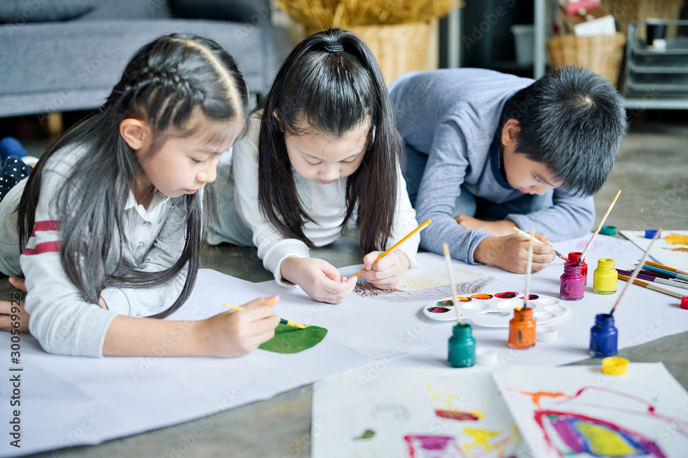 Fototapeta premium Asian family with cute kids painting art in living room at home