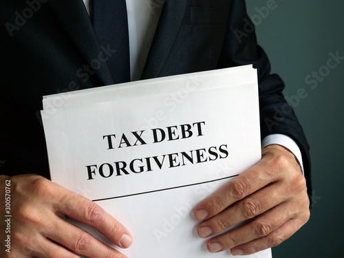 фотографія Man holds Tax debt forgiveness agreement.