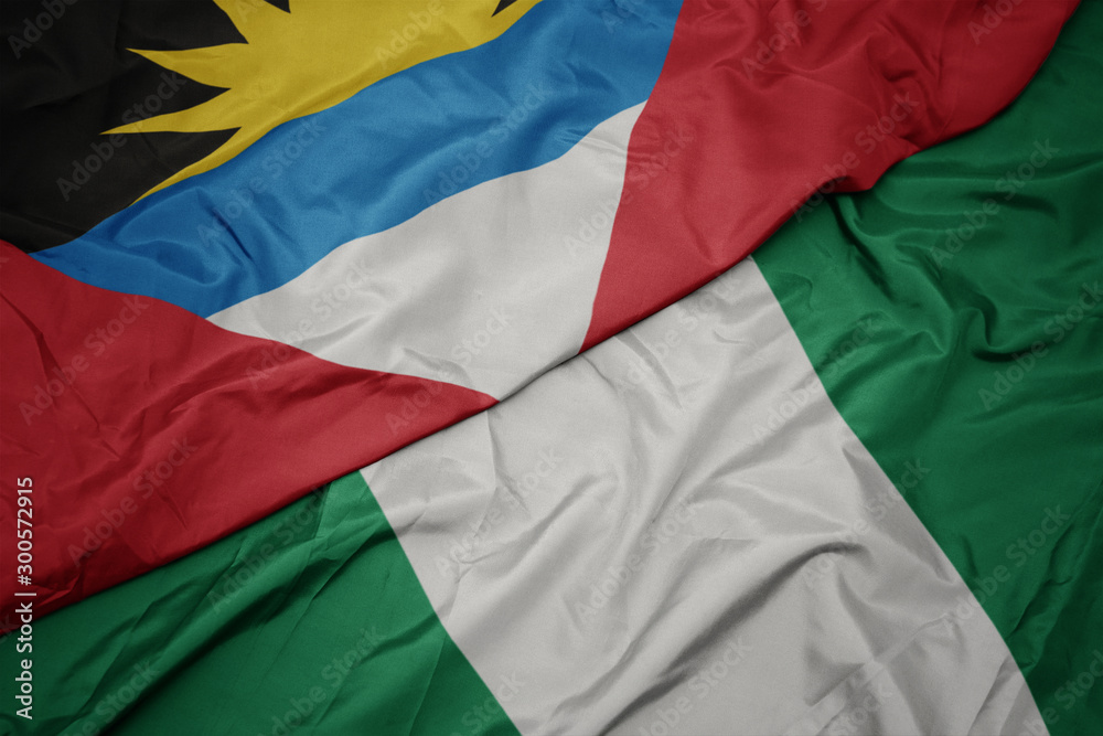 Obraz premium waving colorful flag of nigeria and national flag of antigua and barbuda.