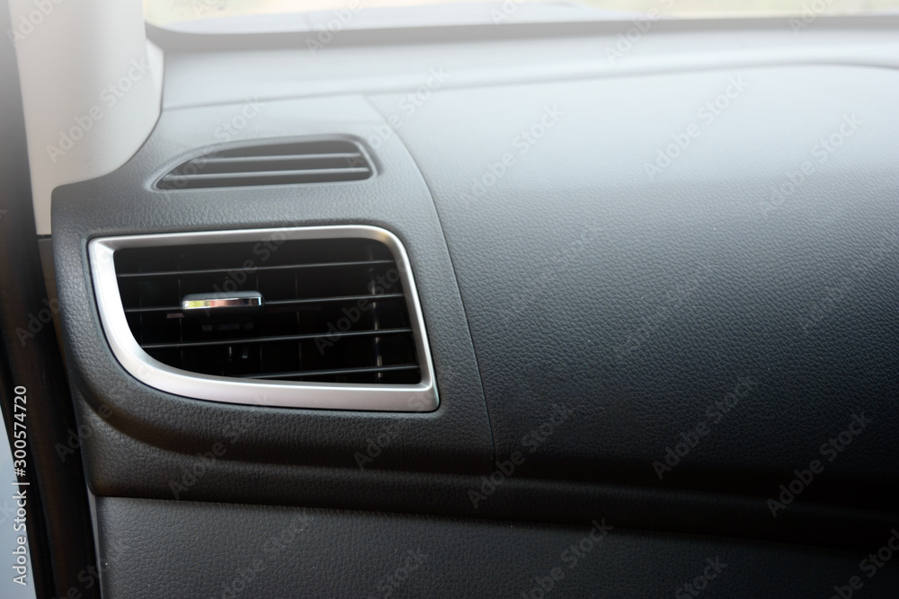 Obraz premium the black grills on top of the hole of air condition vent inside the car on the left of grey leather consol