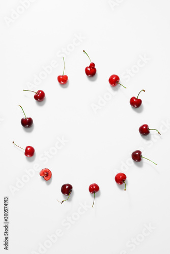 Berries of fresh sweet cherry laid out in the form of a circle on a white surface. Top view.