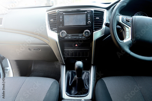 the inside of new car passenger room with velvet seat  gear sticks  hand brake  multi media player and steering wheel
