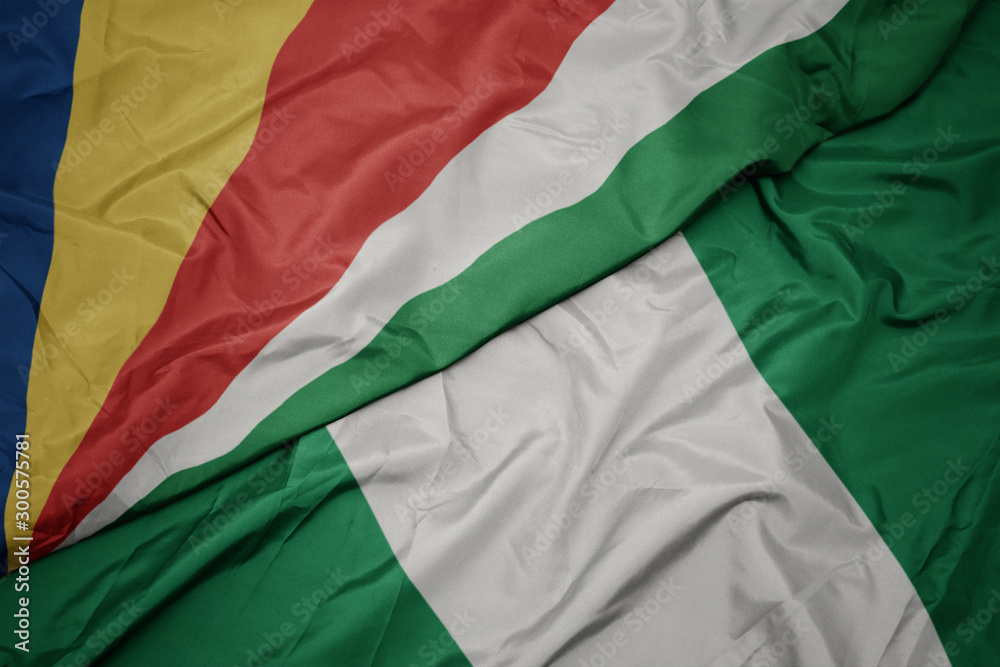 waving colorful flag of nigeria and national flag of seychelles.
