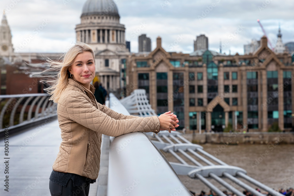 Fototapeta premium Eine hübsche, blonde Touristin in London steht vor der St. Pauls Kirche und geniesst ihren Sightseeing Trip durch die Stadt