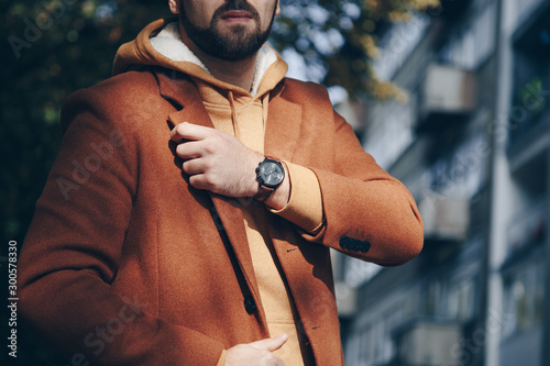 street style 2019 fashion, close up detail of men's fashion accessory. man checking the time on his leather wrist watch.