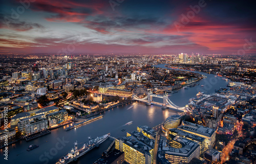 Blick über London: die beleuchtete Skyline von der Tower Brücke entlang der Themse zu den Wolkenkratzern von Canary Wharf am Abend © moofushi