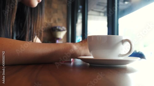 A businesswoman working in a coffee shop with hot coffee