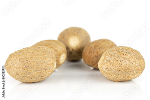 Group of five whole dry brown nutmeg isolated on white background