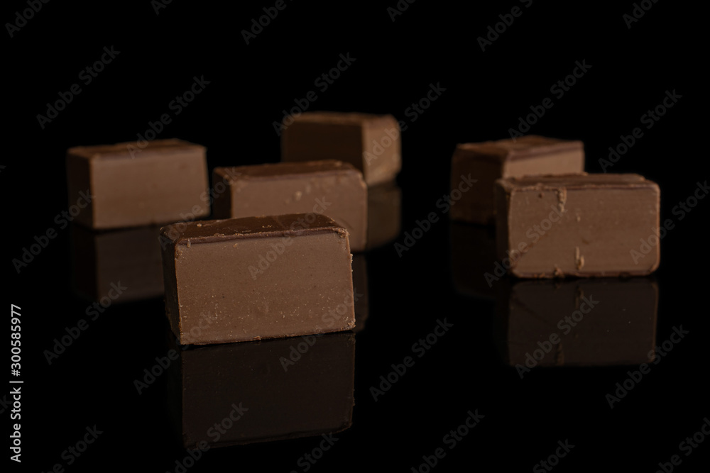 Group of six whole sweet brown viennese nougat isolated on black glass Group of six whole sweet brown viennese nougat isolated on black glass