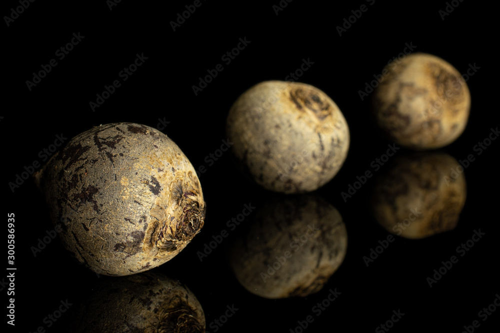 Fototapeta premium Group of three whole raw red beetroot placed diagonally isolated on black glass
