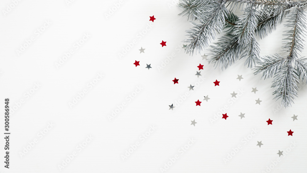 Christmas tree branch and confetti stars on white background. Flat lay, top view, copy space. Xmas banner mockup, winter holidays frame, greeting card template - obrazy, fototapety, plakaty 