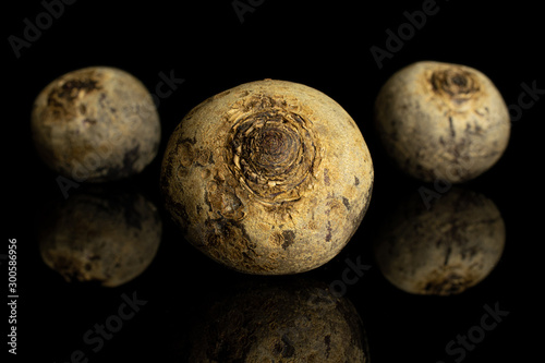 Group of three whole raw red beetroot isolated on black glass