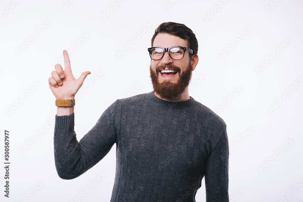 Amazed handsome man with beard wearing eyeglasses and pointing away at copyspace Amazed handsome man with beard wearing eyeglasses and pointing away at copyspace