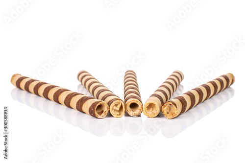 Group of five whole crunchy beige hazelnut rolled wafer biscuit in row isolated on white background