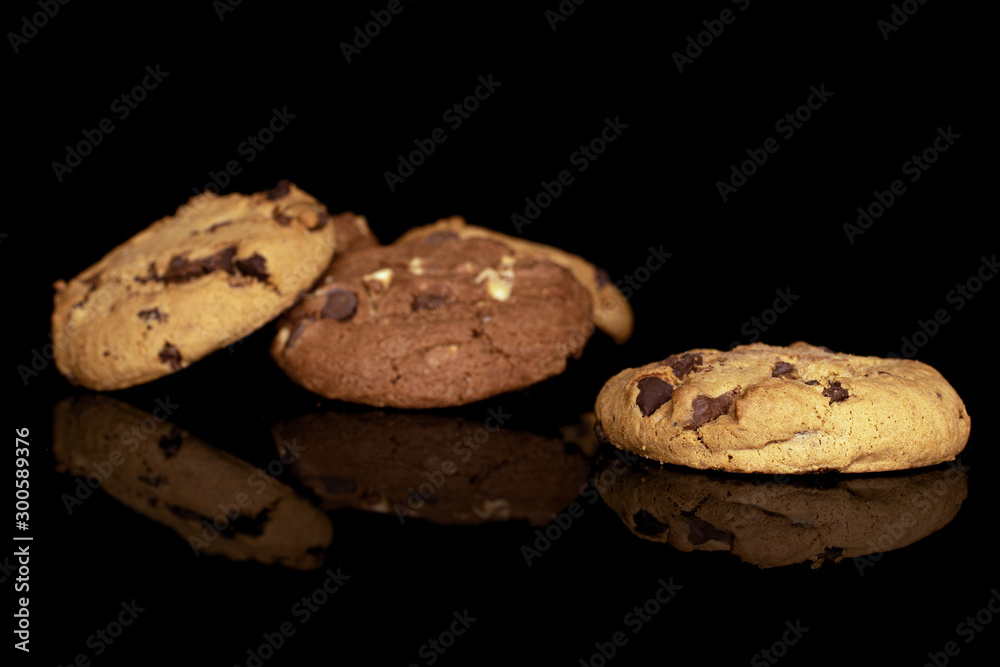 Group of three whole sweet brown cookie isolated on black glass Group of three whole sweet brown cookie isolated on black glass