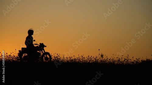 Quadcopter takes off at sunset, quadcopter takes video of motorcyclist photo