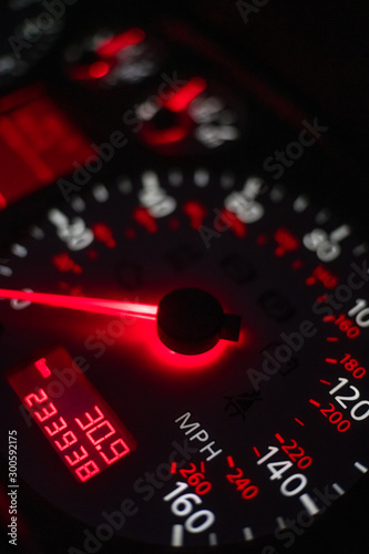 car dashboard. Speedometer with red backlight at night close up. Vertical photo