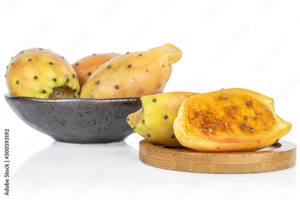 Group of three whole two halves of prickly green opuntia in glazed bowl on round bamboo coaster isolated on white background Group of three whole two halves of prickly green opuntia in glazed bowl on round bamboo coaster isolated on white background
