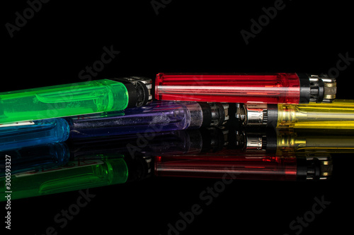Group of five whole plastic lighter isolated on black glass