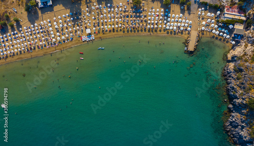 sandy beach with sunbeds and umbrellas, lot of bathing and resting people, view from drone, Greece, Rhodes. Europe