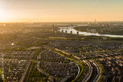 Aerial view of the city Spijkenisse in the township Nissewaard, Holland during sunset. With Hoogvliet, Rotterdam, the industry of the Botlek and the river Old Maas on the background