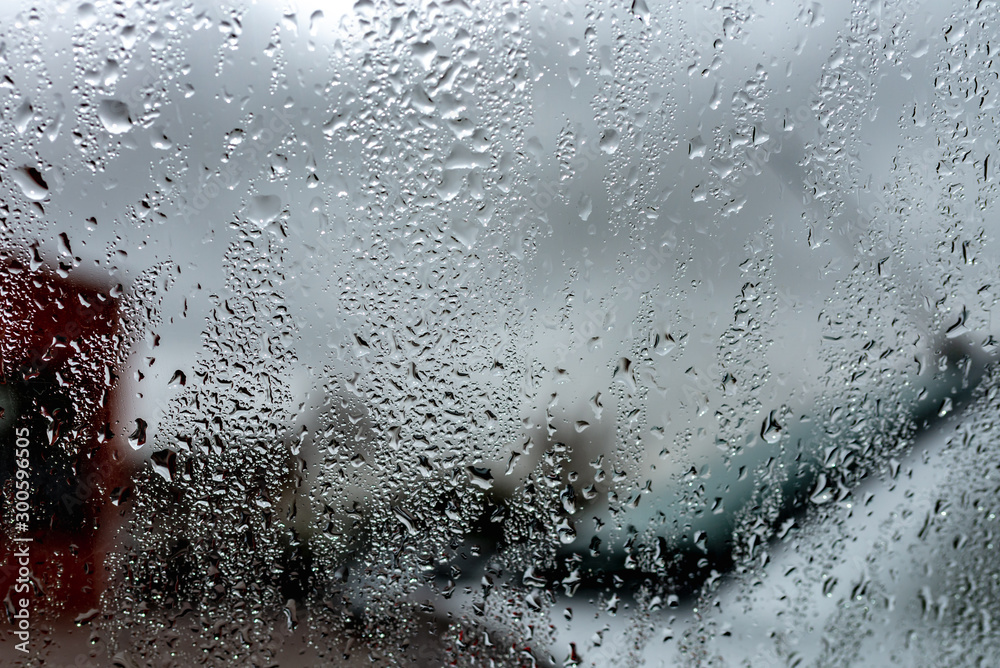 Rain drops on a window against cloudy sky. city in rainy season Rain drops on a window against cloudy sky. city in rainy season
