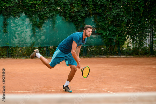 Tennis player standing on one leg after shot © yuriygolub
