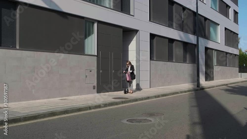 Wallpaper Mural Fashion businesswoman leaving home to go to work on electric scooter Torontodigital.ca