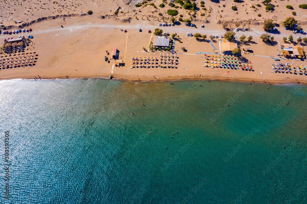 Aerial view of sandy beach with tourists swimming in beautiful clear sea water. Greece Europe