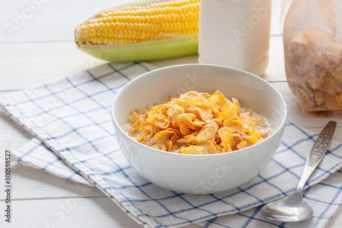 Corn flakes in bowl with milk and cereal corn flakes in plastic pack, energy health, breakfast daily food.