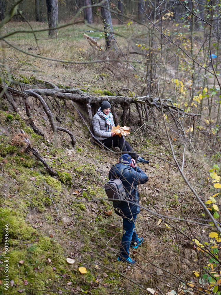 Naklejka premium photographer takes a model in a forest in autumn outdoors