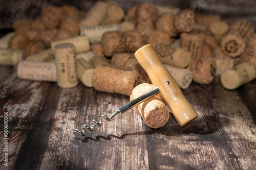 corkscrew and corks on wooden background