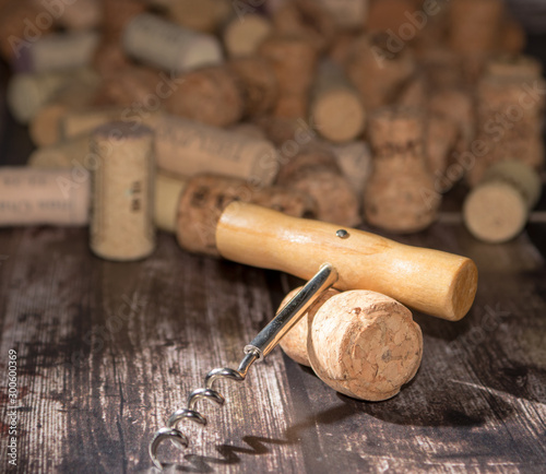 corkscrew and corks on wooden background
