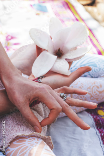 closeup of woman hand in yoga mudra gesture sit in lotus posture outdoor sunny spring summer day