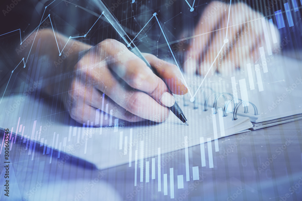 Forex graph on hand taking notes background. Concept of research. Double exposure Forex graph on hand taking notes background. Concept of research. Double exposure