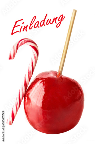 German: Invitation and candied apple on white background