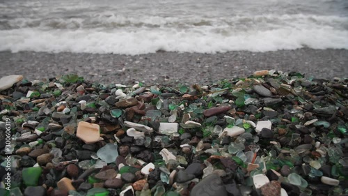 The famous beach with glass fragments stones in Russky Island, Vladivostok. Waves come to land. Environmental pollution