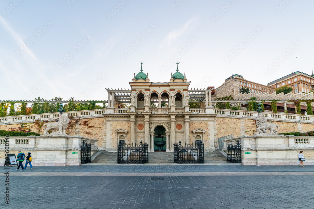 Fototapeta premium Budapeszt, Węgry - 01 października 2019: Widok ulicy na Bazar Castle Garden (Varkert Bazar) zaprojektowany przez Miklosa Ybla, z przechodniami na ulicy Lanchid od północy.