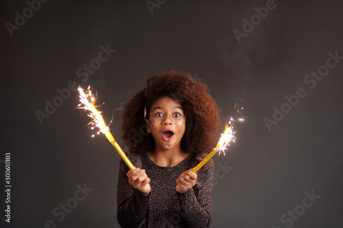 Cute festive girl with burning sparklers