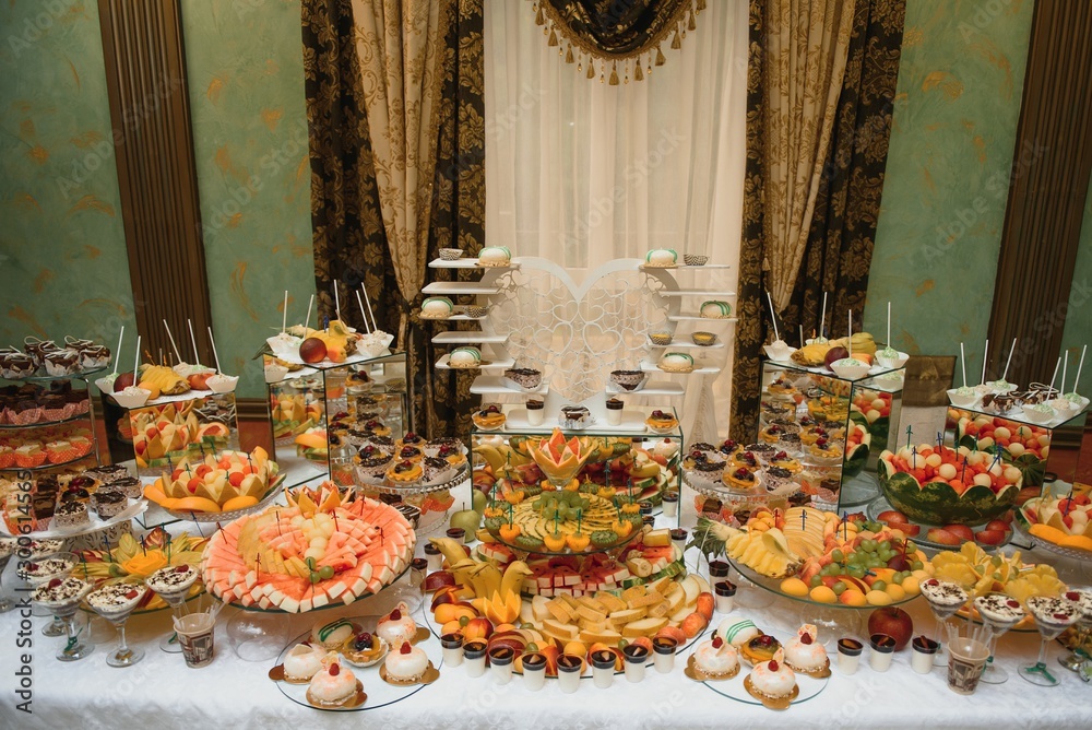 desserts with fruits, mousse, biscuits. Different types of sweet pastries, small colorful sweet cakes, macaron, and other desserts in the sweet buffet