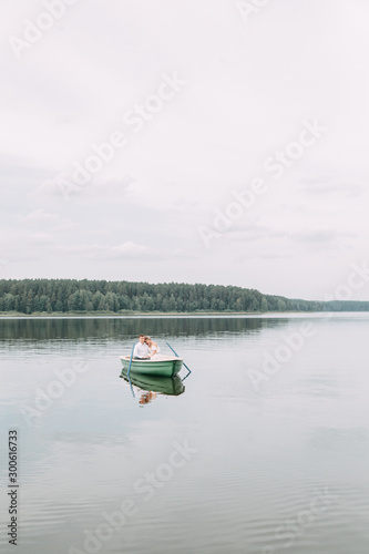  Stylish wedding in European style. Happy couple on a boat on the lake.