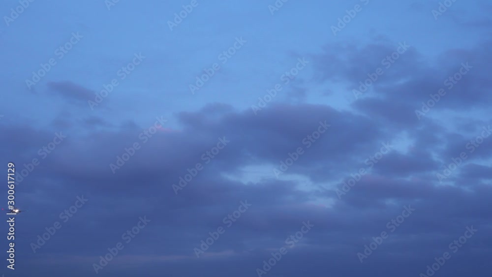 The plane flies in the evening sky. Dusk. Dark blue clouds. The airplane is landing, released the landing gear. Ultra HD stock footage