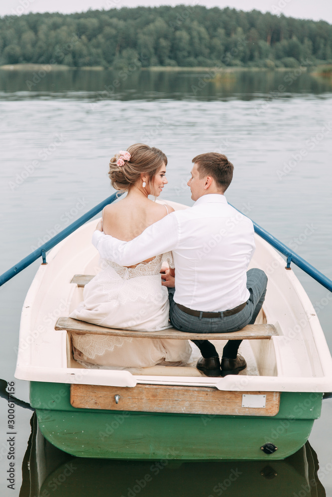Stylish wedding in European style. Happy couple on a boat on the lake. Stylish wedding in European style. Happy couple on a boat on the lake.