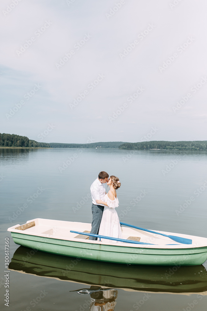  Stylish wedding in European style. Happy couple on a boat on the lake.