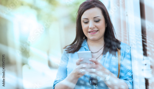 Wallpaper Mural Pretty young woman using her mobile phone in the street Torontodigital.ca