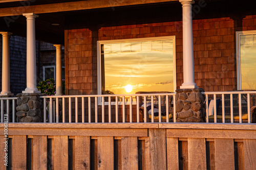 The sun reflects itself in the windows of beachfront homes in the pacifi coast; beautiful, dramatic skies and colors; golden light. Expensive sunset locations. photo