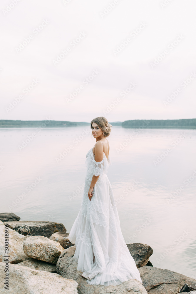 Wedding dress in European style. Happy bride at sunset on the lake. Wedding dress in European style. Happy bride at sunset on the lake.